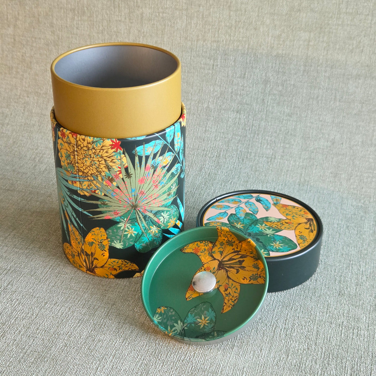 Ronde theeblik met gele en groene bloemenprint op donkere achtergrond, groene deksel, Theeblik Rustik flower Green