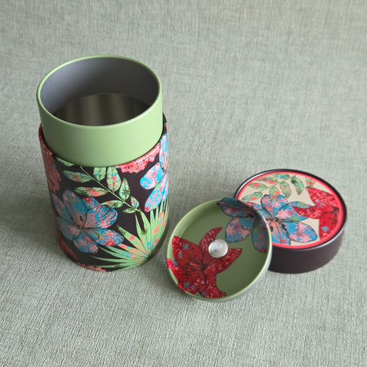 Ronde theeblik met kleurrijke rood-blauwe bloemenprint op zwart, groene deksel ernaast, Theeblik Rustik flower Red