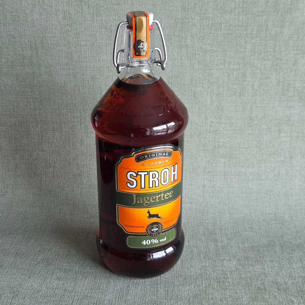 Fles STROH Jagertee 40% vol met oranje etiket en beugelsluiting